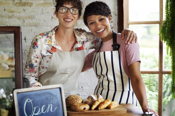 Two women partners in their shop with open sign