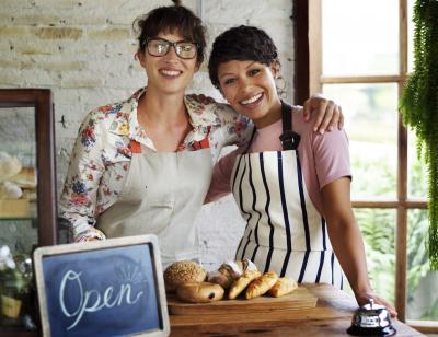 Two women partners in their shop with open sign